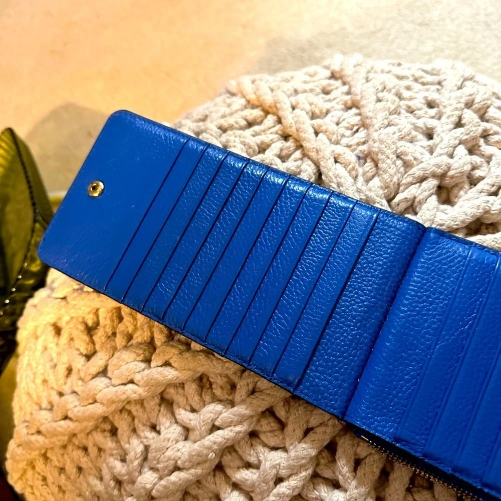Slender wallet holds cash and multiple cards.